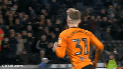 A Soccer Player Wearing An Orange Jersey With The Number 31 On The Back GIF