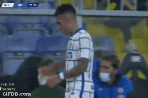 A Soccer Player With A Bandage On His Arm Is Being Helped By A Man Wearing A Mask . GIF