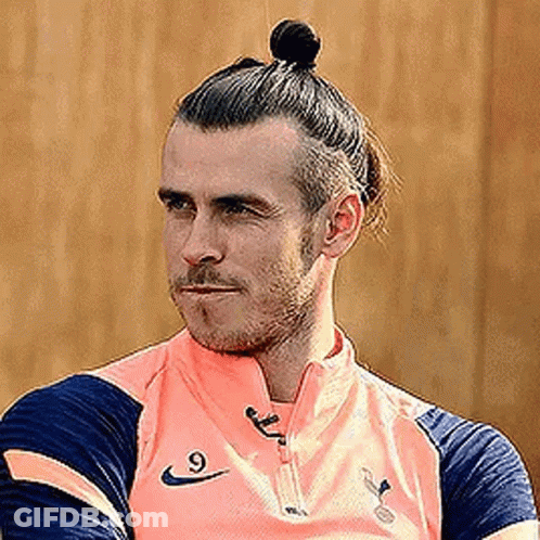 A Soccer Player With A Bun On His Head Is Wearing A Pink Shirt . GIF
