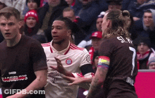 A Soccer Player With A Rainbow Armband Is Being Tackled By Another Player GIF