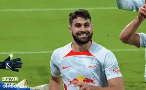 A Soccer Player With A Red Bull On His Shirt Is Smiling GIF