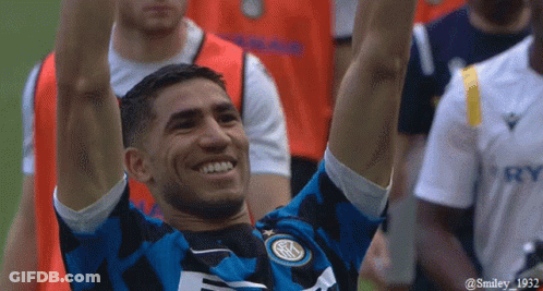 A Soccer Player With His Arms In The Air Is Wearing A Jersey That Says Smiley 1932 On It GIF