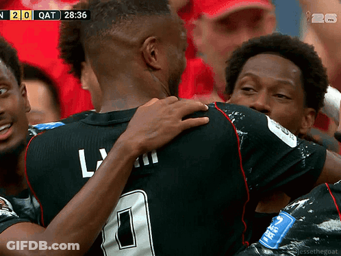 A Soccer Player With The Number 0 On His Jersey Is Hugging Another Player During A Game GIF