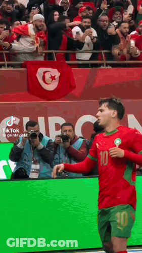 A Soccer Player With The Number 10 On His Jersey Stands In Front Of A Crowd GIF