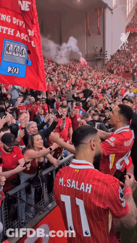 A Soccer Player With The Number 11 On His Back Is Surrounded By Fans GIF