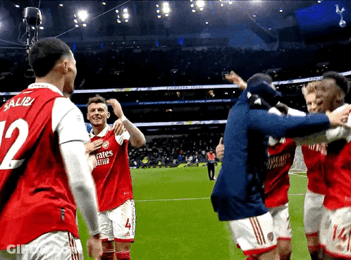 A Soccer Player With The Number 12 On His Jersey Is Surrounded By His Teammates GIF