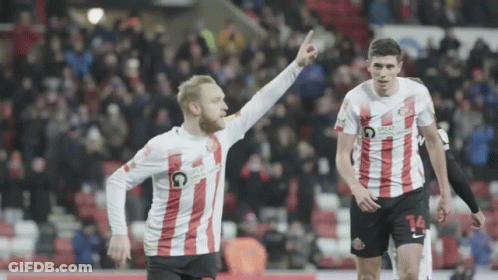 A Soccer Player With The Number 14 On His Shorts Is Pointing Up GIF