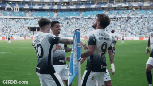 A Soccer Player With The Number 19 On His Back Is Hugging Another Player GIF