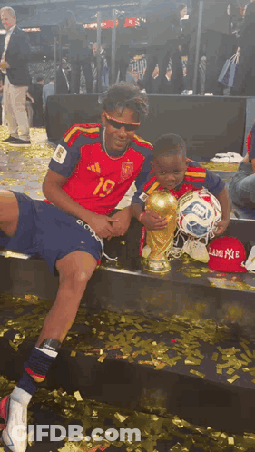 A Soccer Player With The Number 19 On His Jersey Holds A Trophy GIF