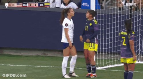 A Soccer Player With The Number 2 On Her Shorts Stands Next To Another Player GIF