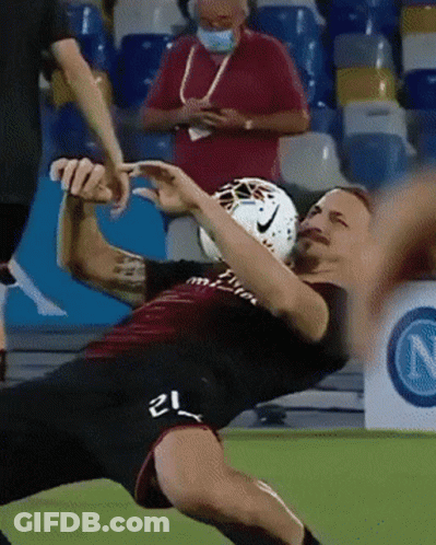 A Soccer Player With The Number 21 On His Shorts Is Falling To The Ground GIF