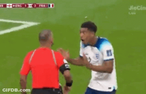 A Soccer Player With The Number 22 On His Jersey Stands In Front Of A Referee GIF