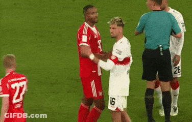 A Soccer Player With The Number 26 On His Shorts Is Kissing Another Player On The Cheek GIF