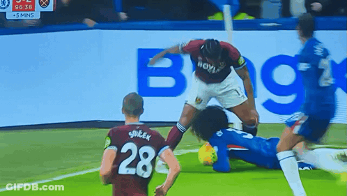 A Soccer Player With The Number 28 On His Jersey Is Being Tackled By Another Player GIF