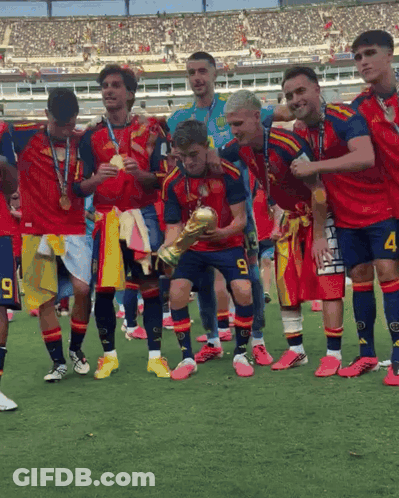 A Soccer Player With The Number 9 On His Shorts Is Holding A Trophy With His Teammates GIF