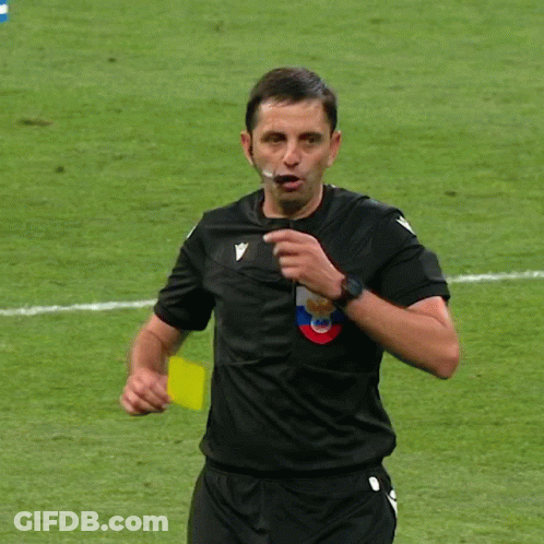 A Soccer Referee Holds Up A Yellow Card With A Crown On It GIF