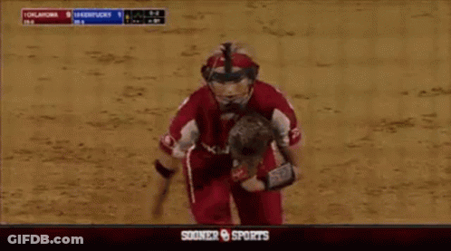 A Softball Player Wearing A Helmet And Glove Runs Towards A Scoreboard That Says Sooner Sports GIF