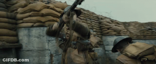 Soldier Holding Gun In Front Of Sandbag Wall GIF