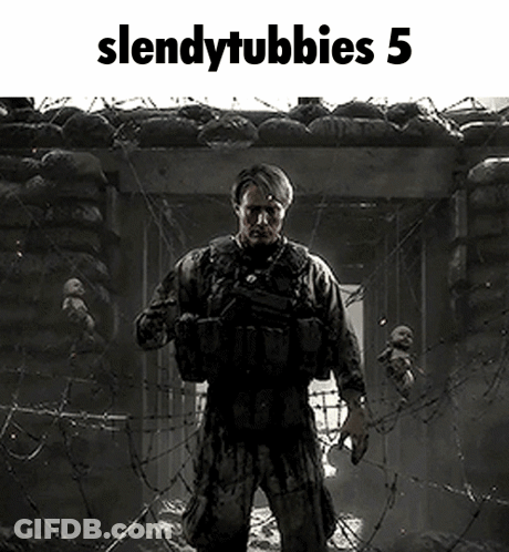 A Soldier Is Standing In Front Of A Barbed Wire Fence Holding A Gun . GIF