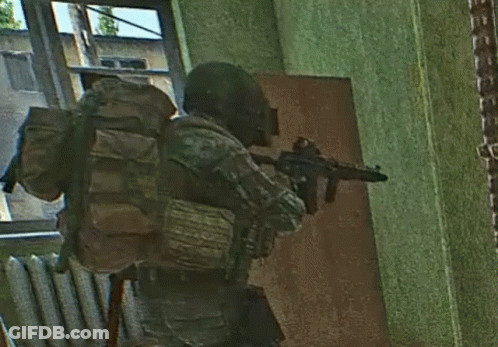 A Soldier With A Backpack Holding A Gun In A Room GIF