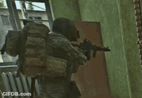 A Soldier With A Backpack Is Holding A Gun In Front Of A Door . GIF