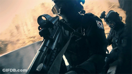 A Soldier With A Korean Flag On His Back Holds A Rifle GIF