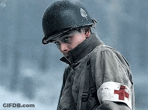 A Soldier With A Red Cross On His Arm Is Wearing A Helmet . GIF