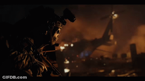 A Soldier With A Skull Mask On His Face Holds A Gun GIF