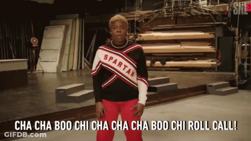 A Spartan Cheerleader Is Standing On Stage GIF