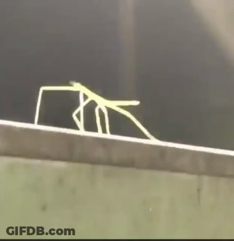 A Spider Is Crawling On A Metal Railing In A Dark Room GIF