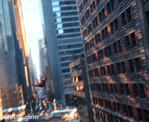 A Spider-Man Is Flying Through The Air In A City GIF