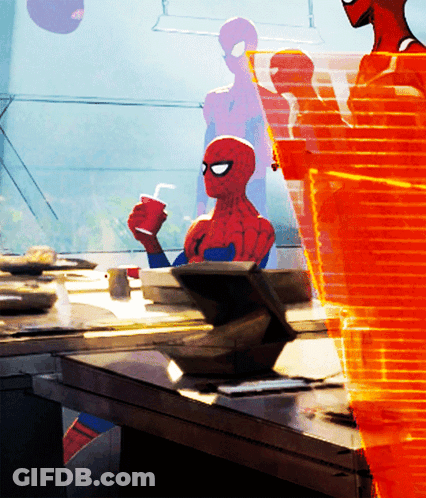 A Spider Man Sitting At A Table Holding A Cup Of Coffee GIF