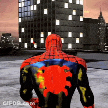 A Spider Man With A Red Spider On His Back Stands In Front Of A Building GIF