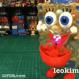 A Spongebob Doll Is Standing On A Green Cutting Board . GIF