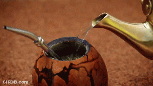 A Spoon Is Being Used To Pour Liquid Into A Bowl GIF