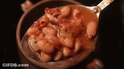 A Spoon Is Scooping Beans Out Of A Bowl . GIF
