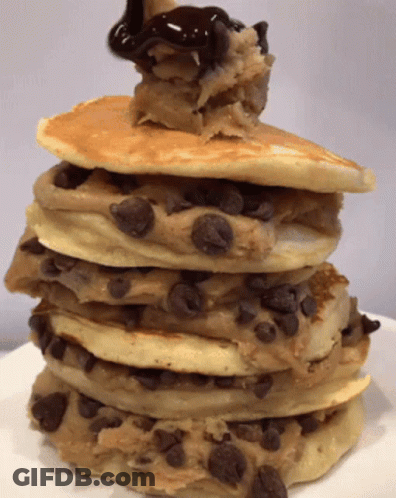 A Stack Of Cookies And Cream Pancakes With Chocolate Sauce On Top GIF