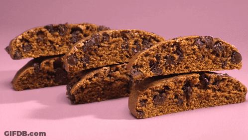 A Stack Of Cookies With Chocolate Chips On A Pink Surface GIF