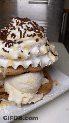 A Stack Of Cookies With Ice Cream And Whipped Cream GIF