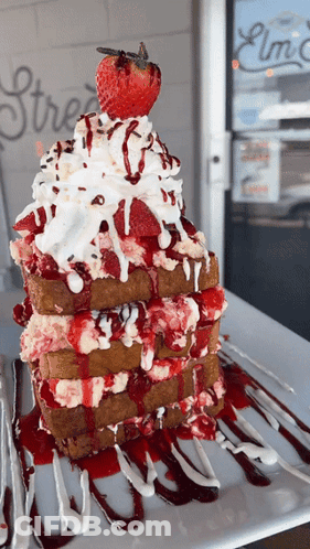 A Stack Of French Toast With Whipped Cream And Strawberry Sauce GIF