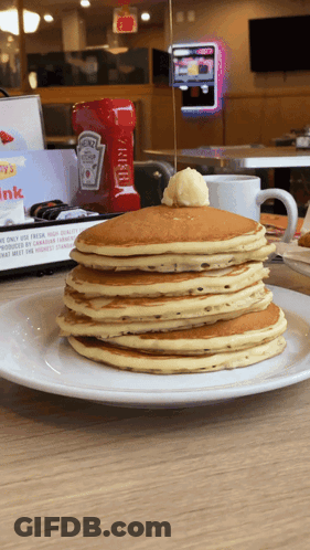 A Stack Of Pancakes On A Plate With A Bottle Of Heinz Ketchup Behind Them GIF