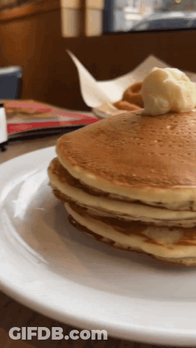 A Stack Of Pancakes On A Plate With Butter On Top GIF