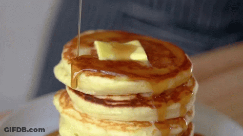 A Stack Of Pancakes With Butter And Syrup Being Poured On Top GIF