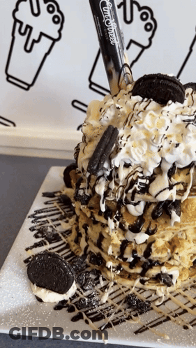 A Stack Of Pancakes With Oreos And Whipped Cream On Top GIF