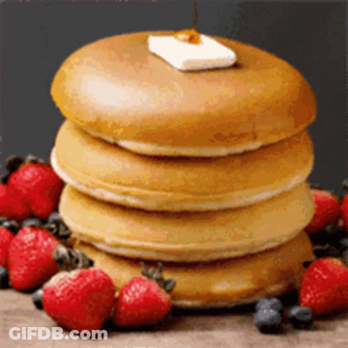 A Stack Of Pancakes With Strawberries And Blueberries On Top GIF