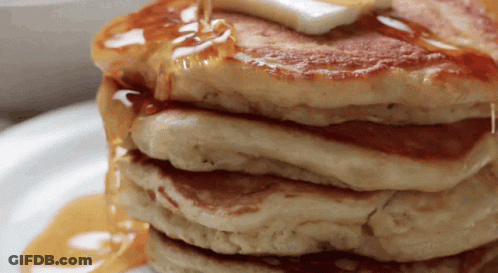 A Stack Of Pancakes With Syrup Being Poured On Them GIF