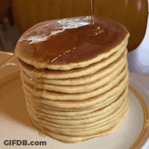 A Stack Of Pancakes With Syrup Being Poured On Top Of Them GIF