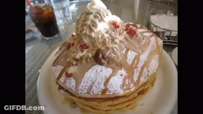 A Stack Of Pancakes With Whipped Cream And Strawberries On Top On A Plate . GIF