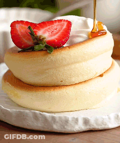 A Stack Of Pancakes With Whipped Cream And Strawberries GIF