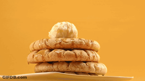 A Stack Of Peanut Butter Cookies On A White Plate With A Tong GIF